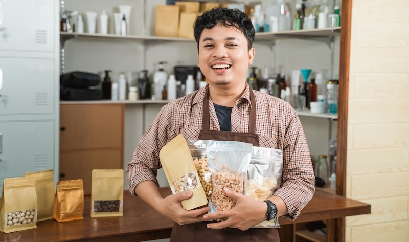 Brand owner in their shop holding packaged products