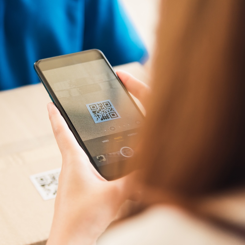 Person scanning a QR code on a package with a smartphone
