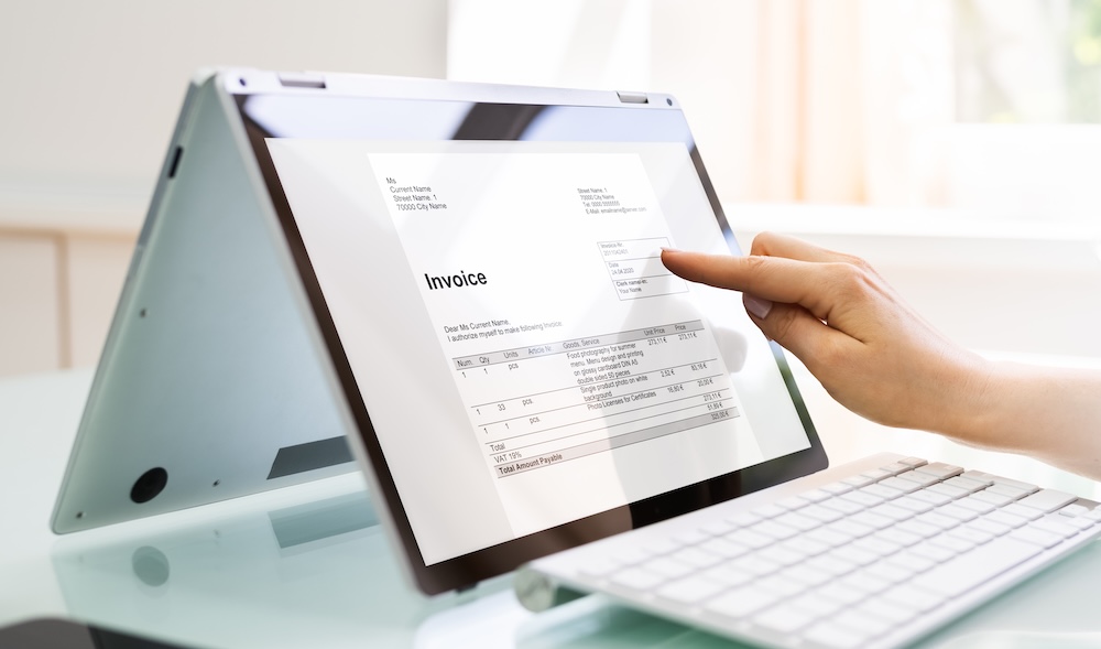 Person reviewing a digital invoice on a laptop screen